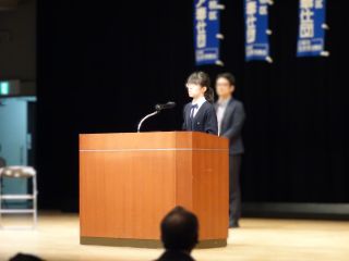 高校生ボランティア「ココボラ」の団員１名によるPRの様子の写真。女の子が笑顔で話をしている。
