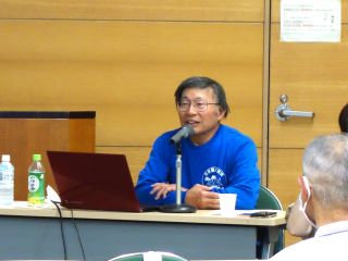 講師の藤野氏の写真。70代の男性。メガネをかけている。