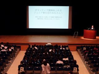 講演の様子の写真。講堂の後ろの方から撮影。
