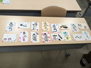 親子イベントの写真。はがき大の紙に遊書が書かれている。「ありがとう」「心」「すき」などの文字が個性的に書かれている。