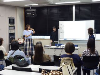 手話ボランティアフォローアップ講座の写真。受講者が1名ずつ前に立ち、手話で自分の名前や住んでいるところ、仕事や趣味などを自己紹介している様子。