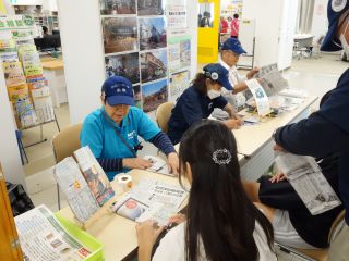 昨年度開催時の写真。防災リーダー会のブースで、子どもたちと一緒に新聞紙でスリッパを作っている。