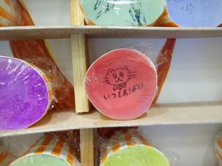 スライム企画の写真。パネルに並んだスライムの拡大写真。赤いスライムで、透き通っていてカップの底に書かれた文字と絵がよく見える。猫のイラストと「いつもありがとう」と書かれている。