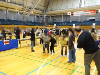 パン食い競争の写真。洗濯竿に等間隔で紐をつけていて、その先にパンがついている。一列にスタートした参加者がパンを口で咥えようと頑張っている。