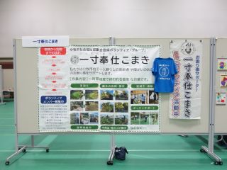 展示ブースの写真。ボランティアグループの活動紹介やのぼり、活動で使うTシャツがパネルに貼られている。