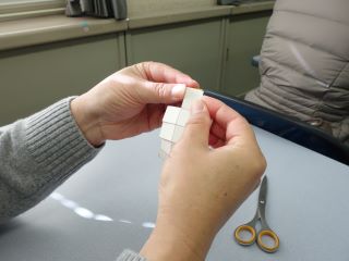 折れ線にしたがって牛乳パックを折っている写真。