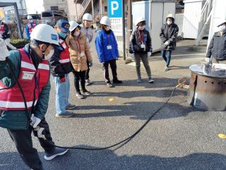 災害ボランティアの実習の写真。炊き出し用のはそりの設置をしている。