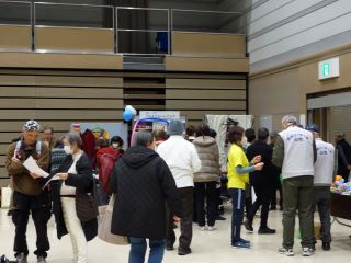 つどいの写真。会場の各ブースに数十人が展示を見たり体験をしたりして楽しんでいる。