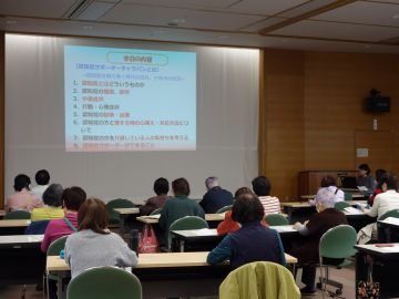 勉強会の様子の写真。前のスクリーンに映し出されたパワーポイントの映像を見ながら講師の話を聞いている様子。