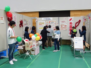 昨年の様子の写真。共同募金のブースでは来場者に風船が配られている。パネルに貼られた展示物を来場者が眺めている。