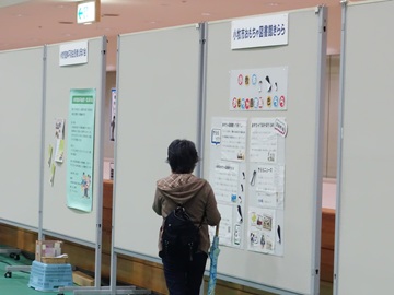 昨年の様子の写真。パネルに貼られた展示物を来場者が読んでいる様子。