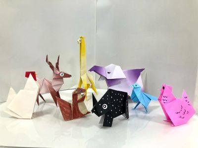 折り紙で作られた動物たちの写真。鶏、鹿、リス、キリン、サイなど、さまざまな動物が折り紙で立体的に折られ、並んでいる。