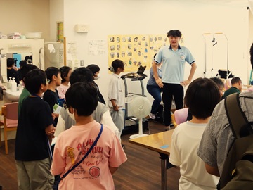 障がい者デイサービスで、職員から説明を受けている子どもたちの様子。